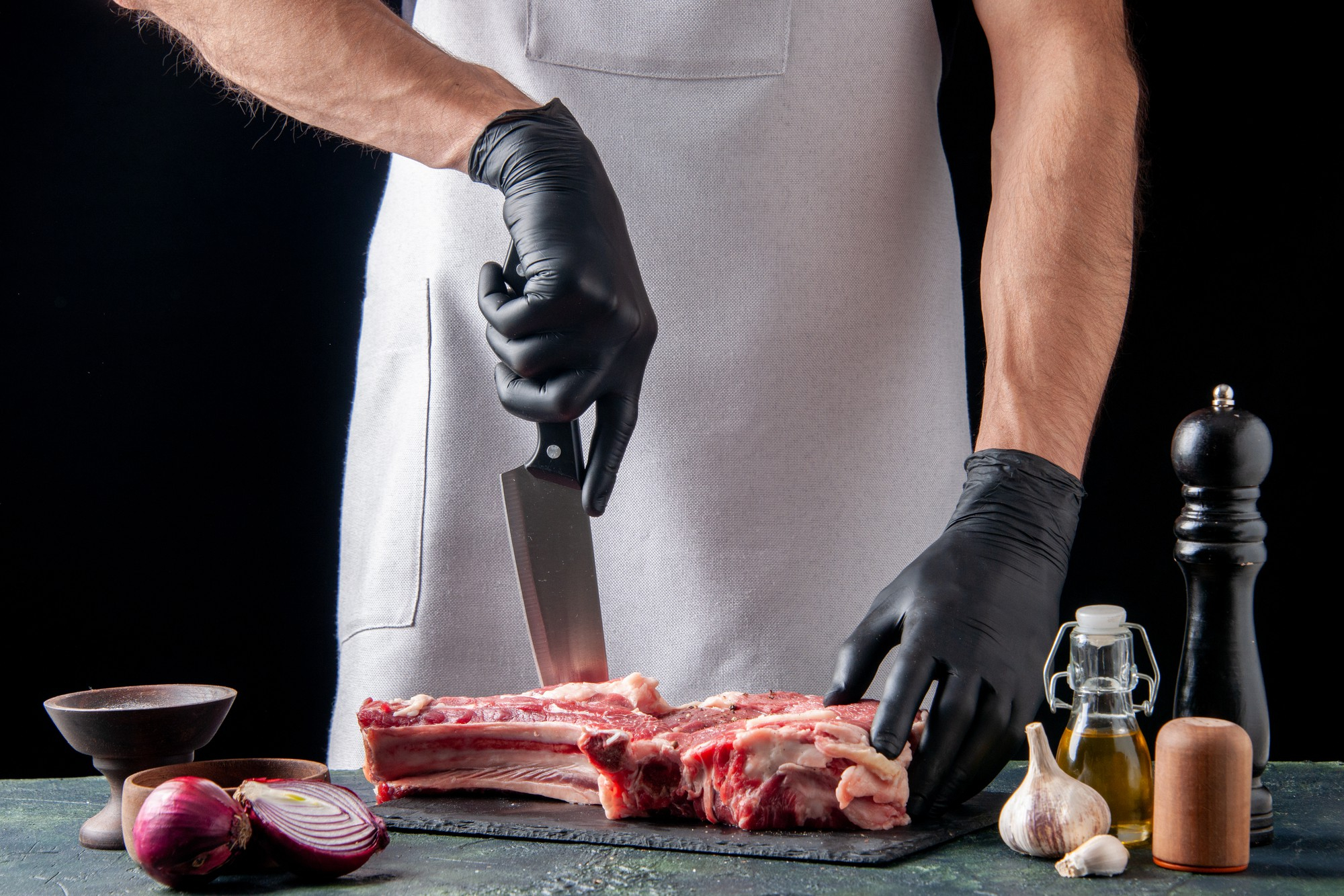 front-view-male-butcher-cutting-meat-dark-surface
